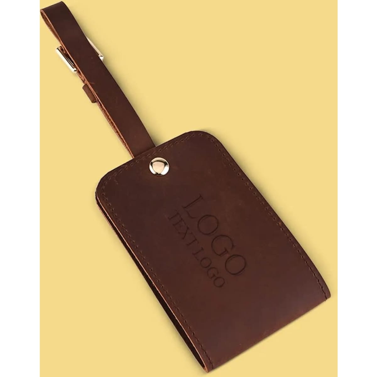 A brown genuine leather luggage tag with a strap and a logo. The tag features a sleek, minimalist design.