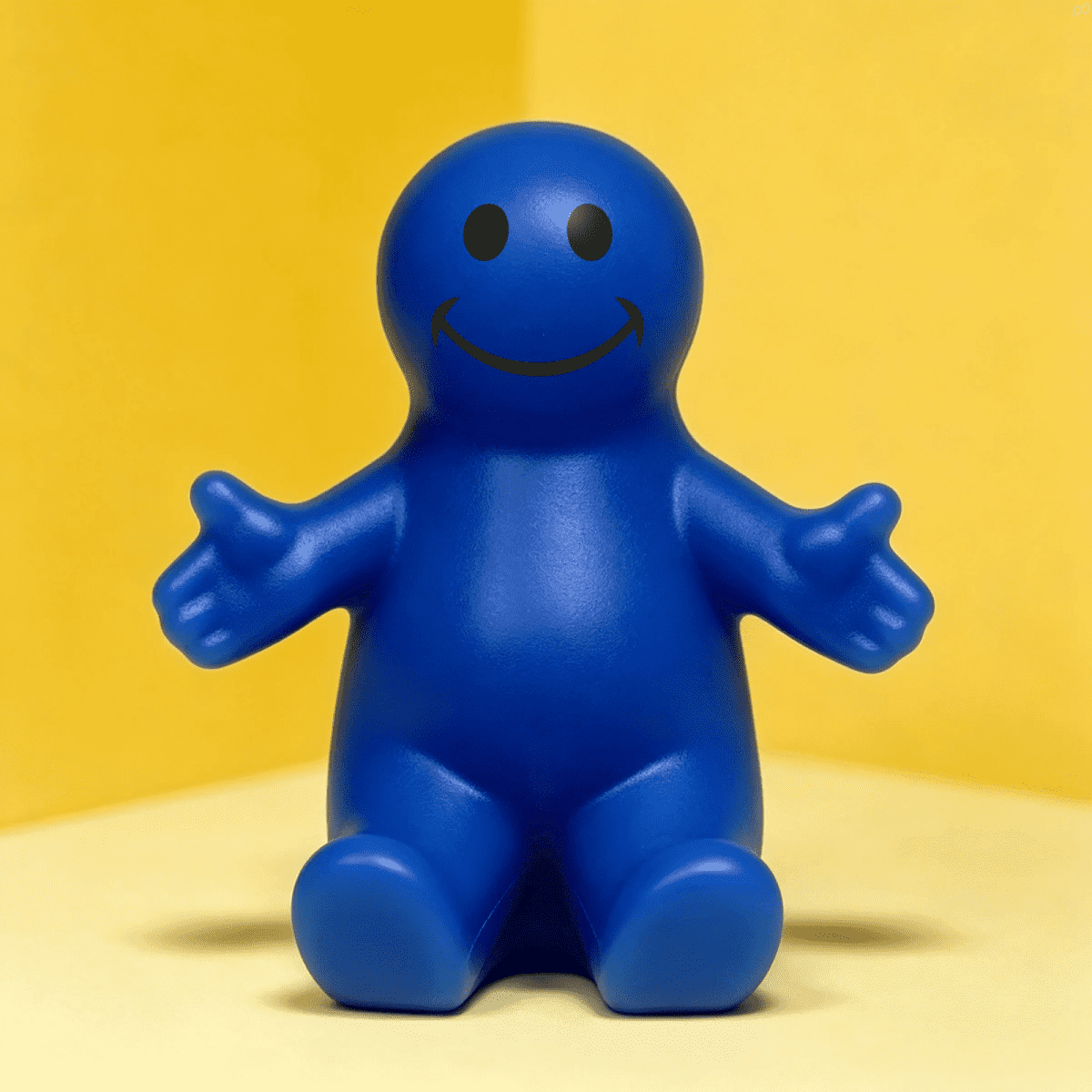 A blue, smiling figurine with outstretched arms, designed as a stress ball and phone stand.