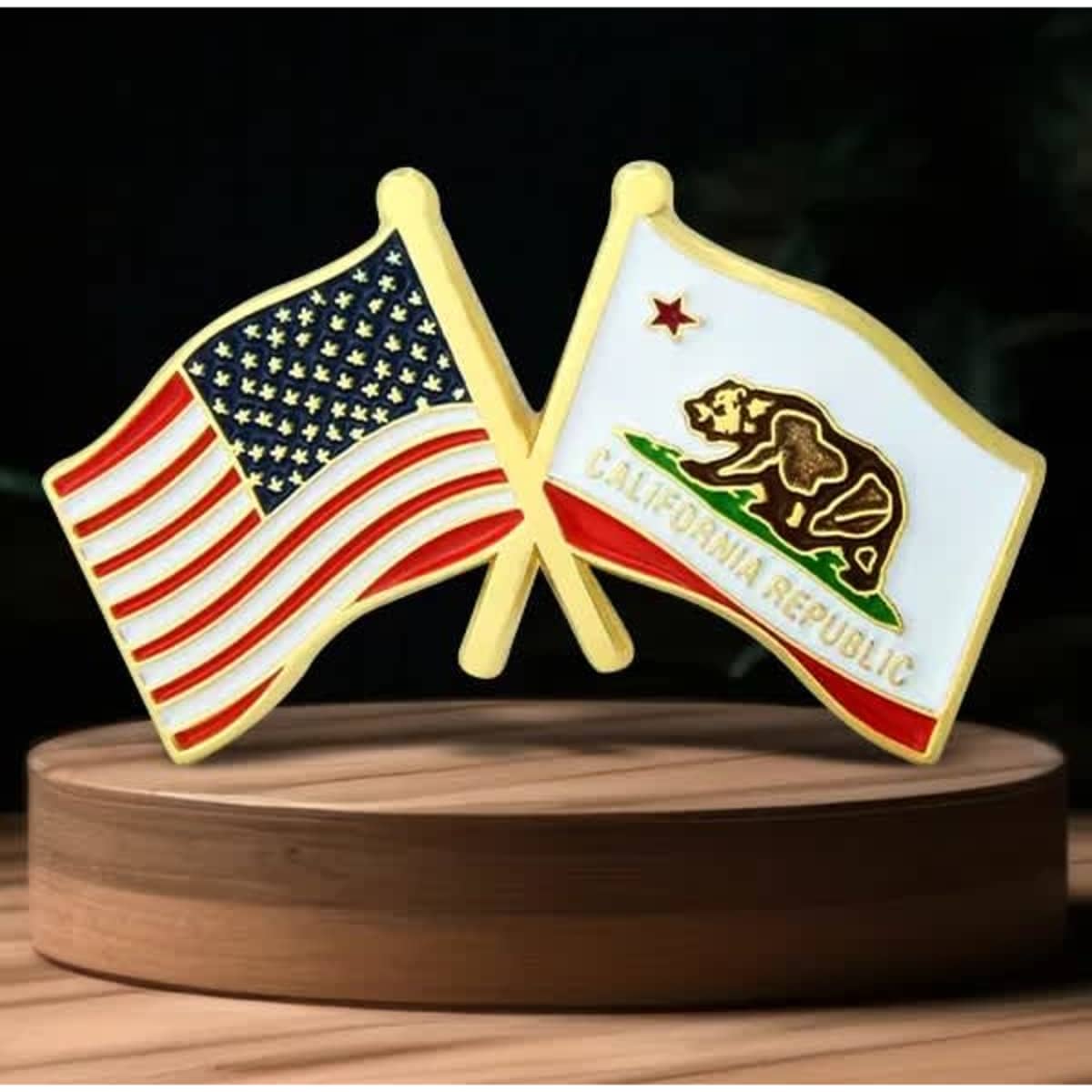 A lapel pin featuring crossed flags of the USA and California, in red, white, blue, and gold.