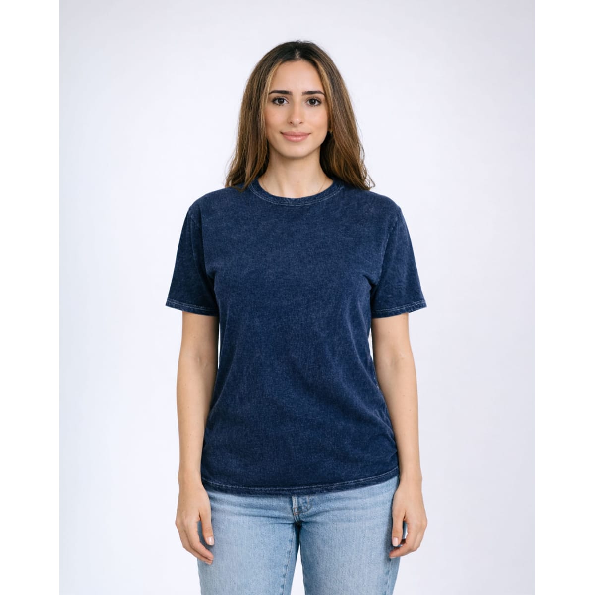 A woman models a navy blue Colortone® Mineral Wash adult t-shirt. The shirt has a rounded neckline and short sleeves.