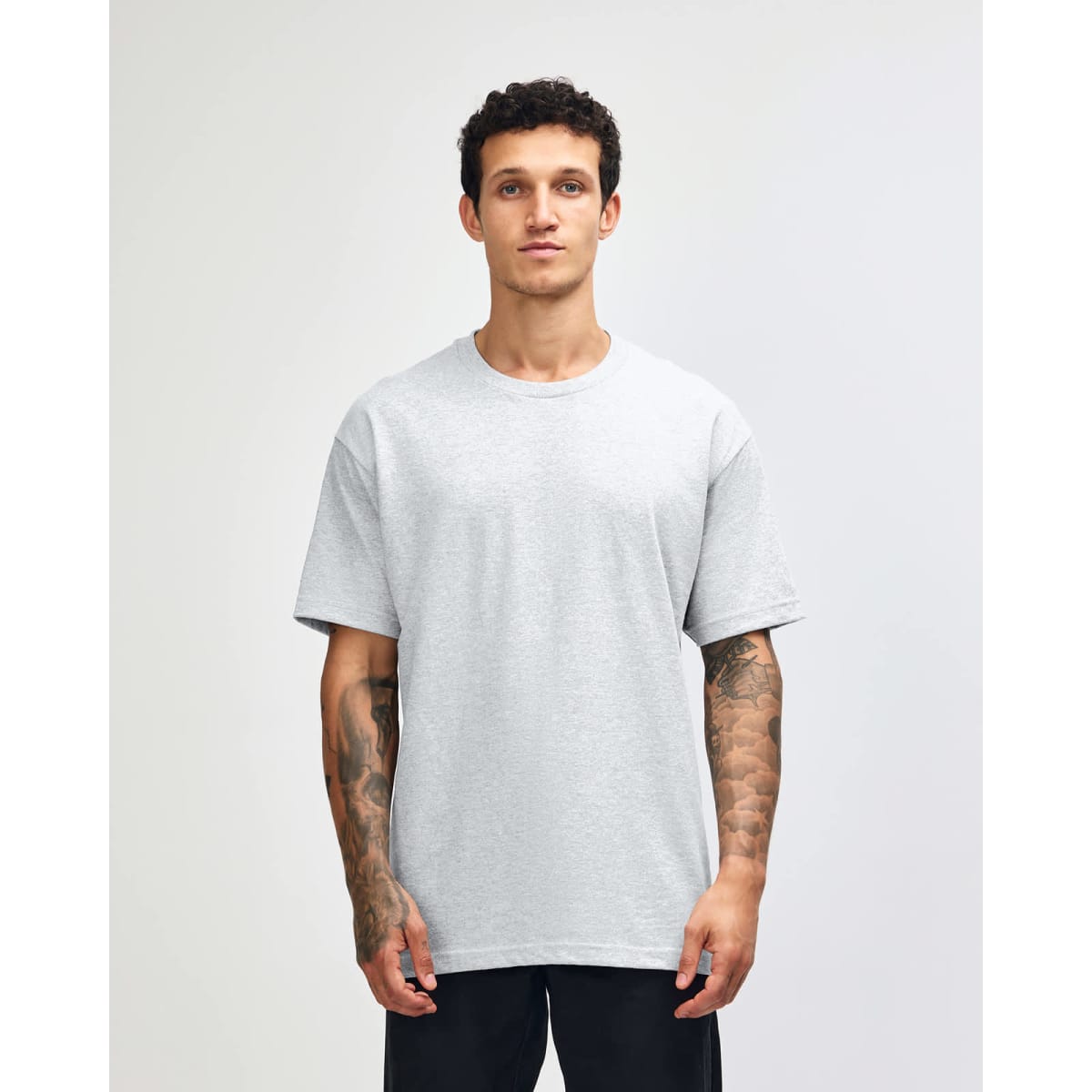 A lightweight grey unisex t-shirt is displayed on a model, featuring a relaxed fit and plain design.