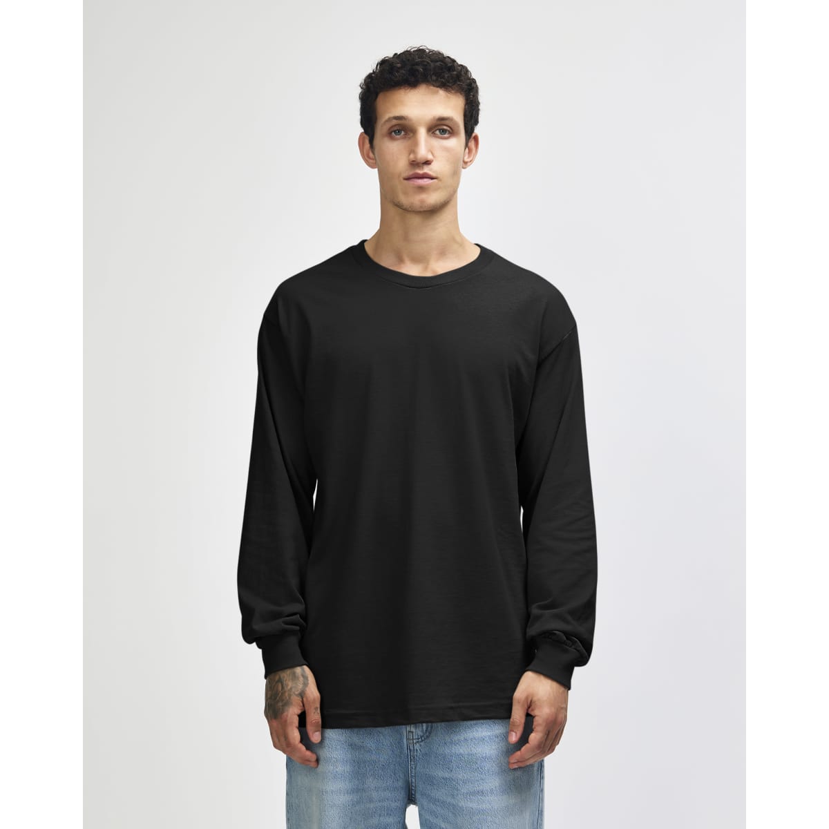 A black heavyweight cotton unisex long sleeve T-shirt on a model, featuring a logo.
