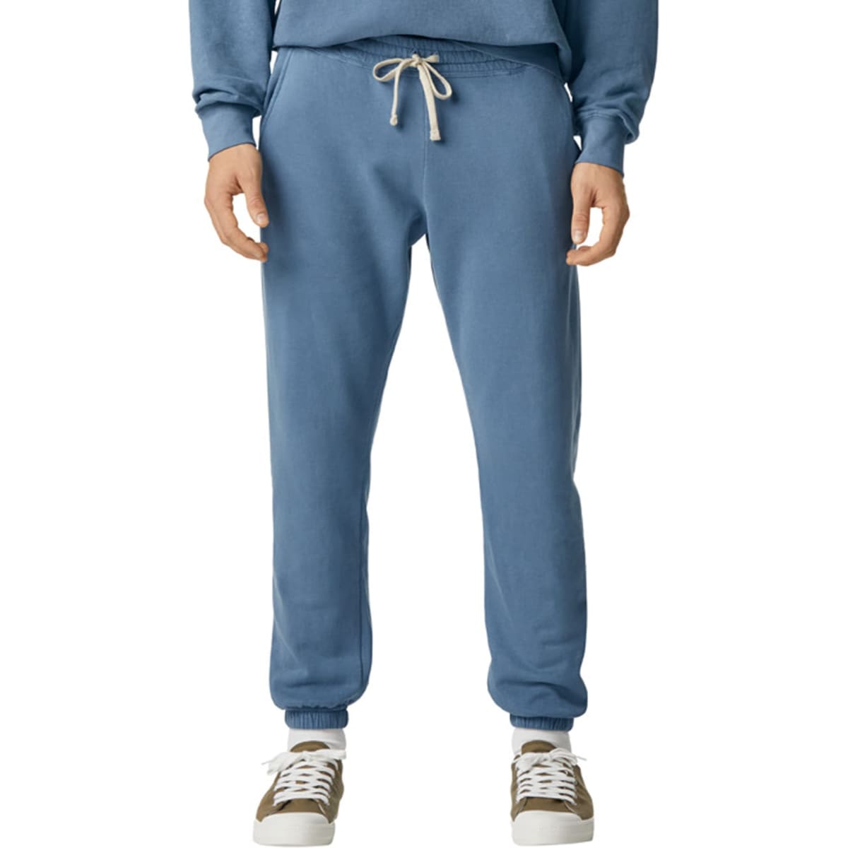 Lightweight sweatpants in a soft blue colour, featuring an elastic waist and drawstring. Paired with casual footwear.