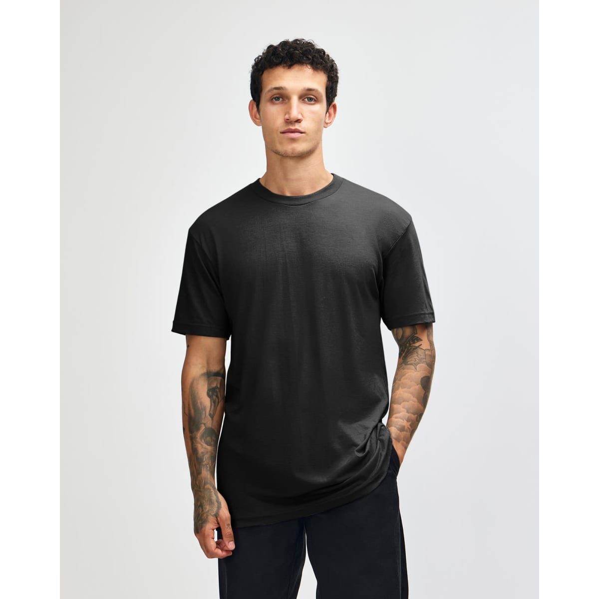 A unisex black CVC short sleeve t-shirt displayed on a model, featuring a simple design and fitted style.