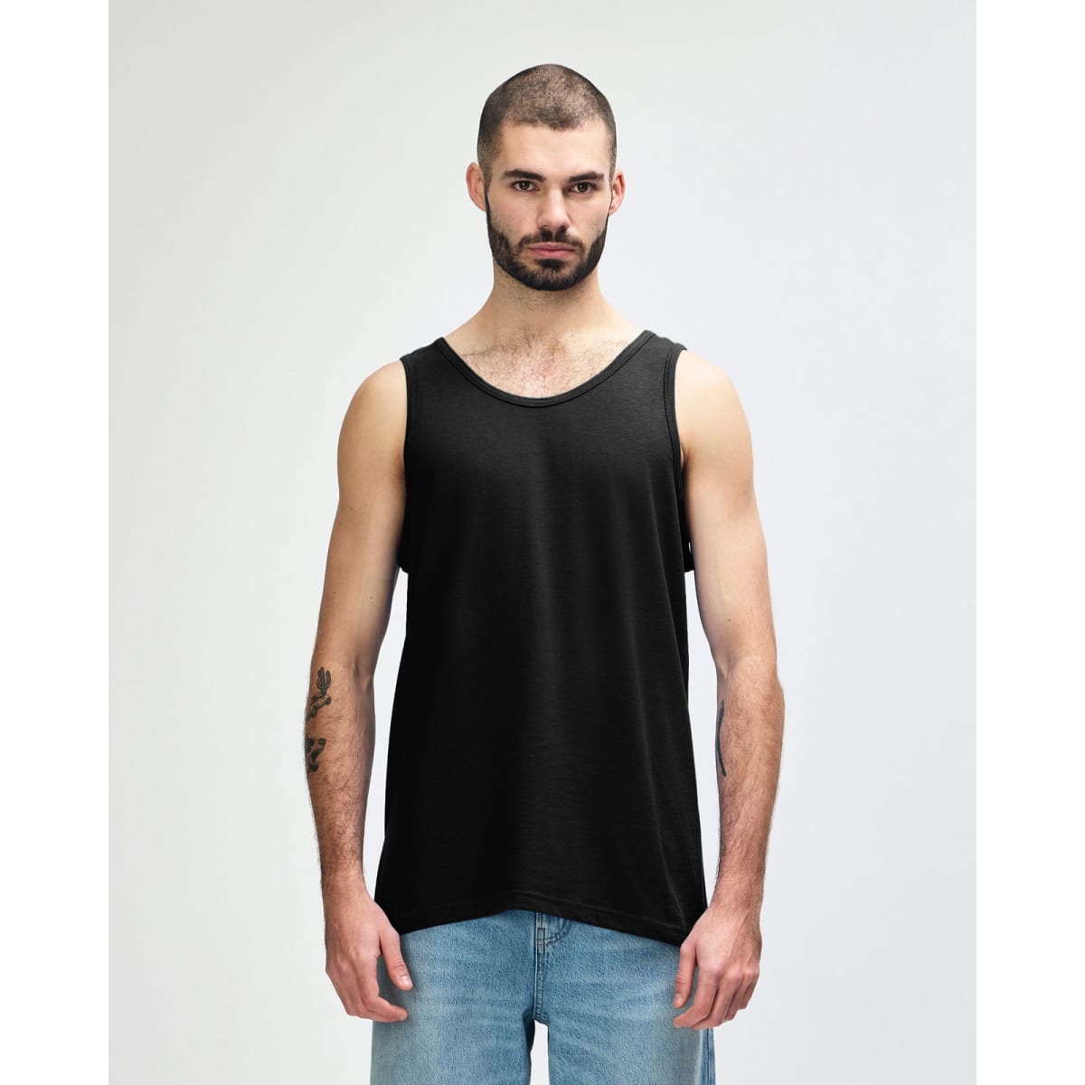 A black Gildan Heavy Cotton adult tank top on a model, featuring a plain design and a logo on the label.