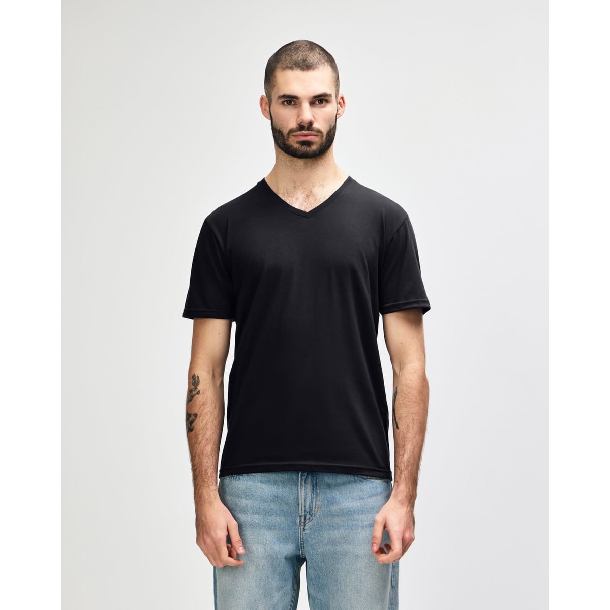 A black Gildan Softstyle adult v-neck t-shirt displayed on a model. The shirt features a branding logo.