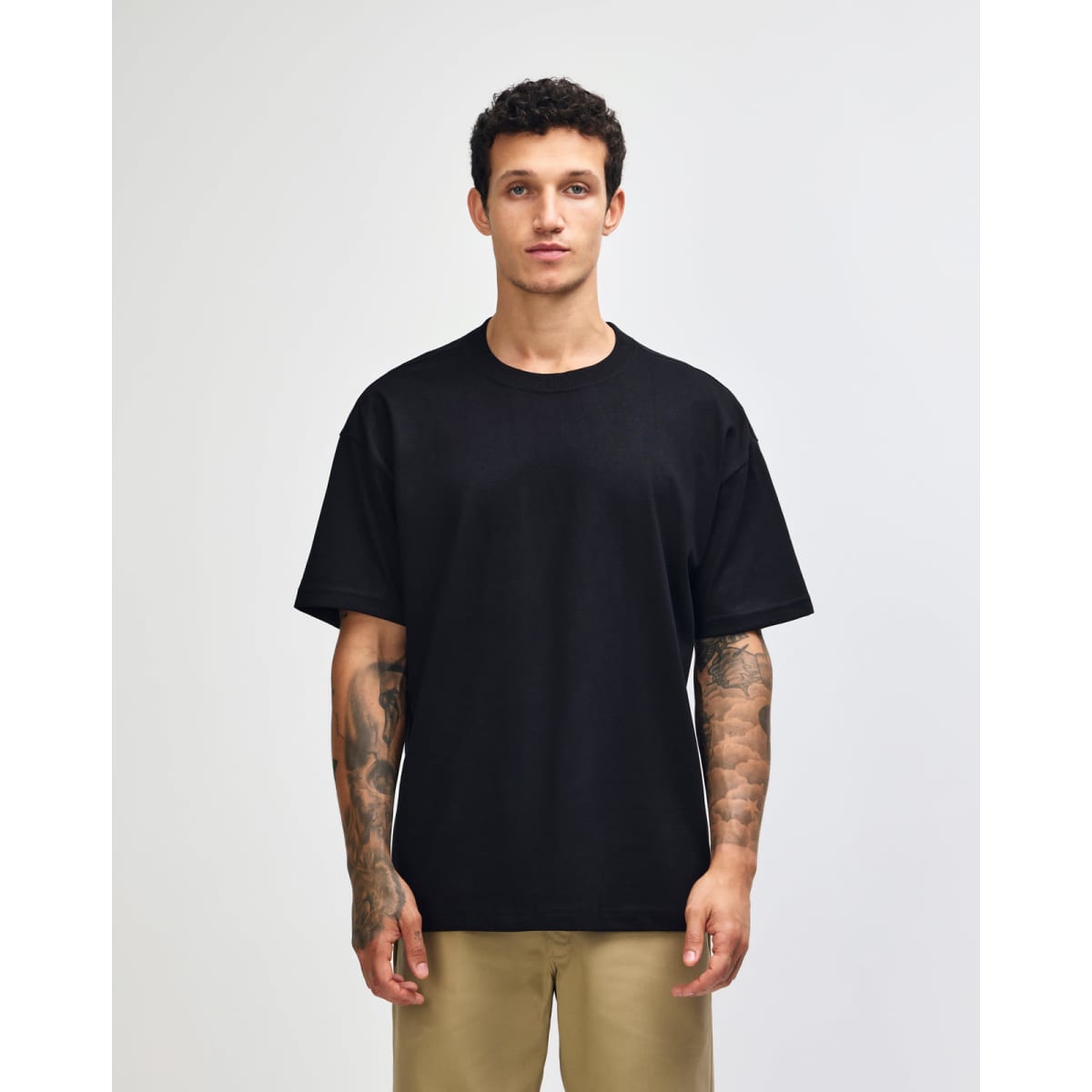 A dark navy heavyweight t-shirt displayed on a model, featuring a simple design and a logo.