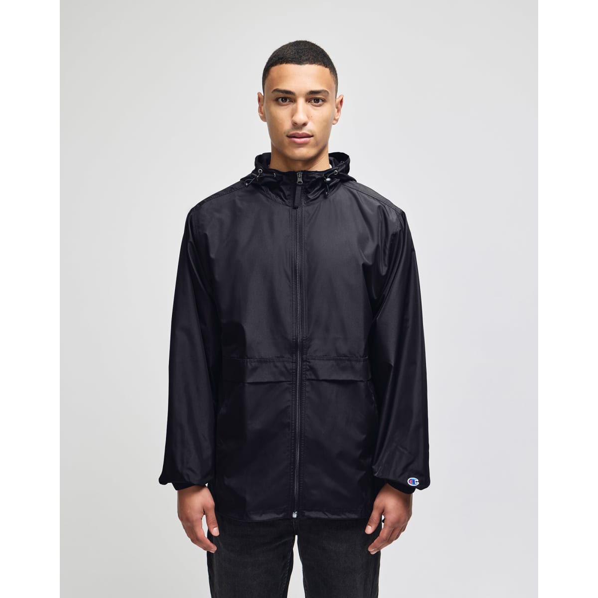 A black full-zip anorak jacket with a hood, featuring a front pocket and a logo.