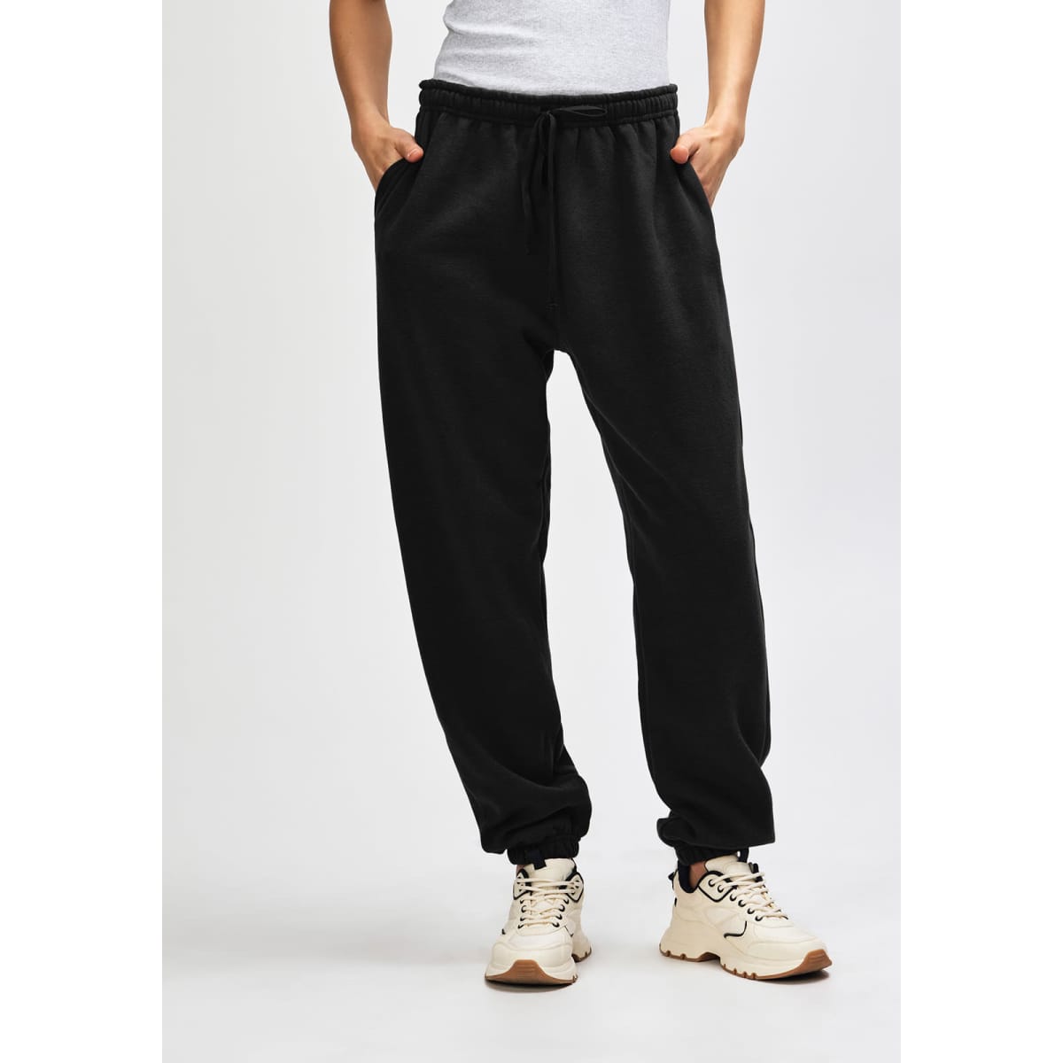 Black unisex sweatpants with an elastic waistband and drawstring, featuring a logo on the side.