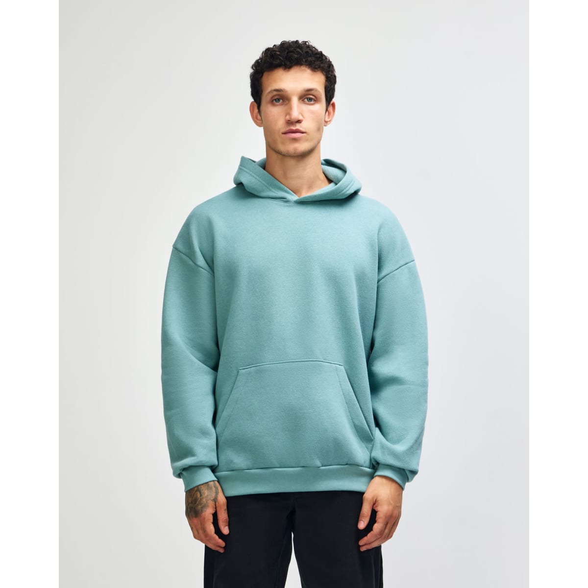A unisex hooded sweatshirt in mint green with a front pocket and a brand logo.