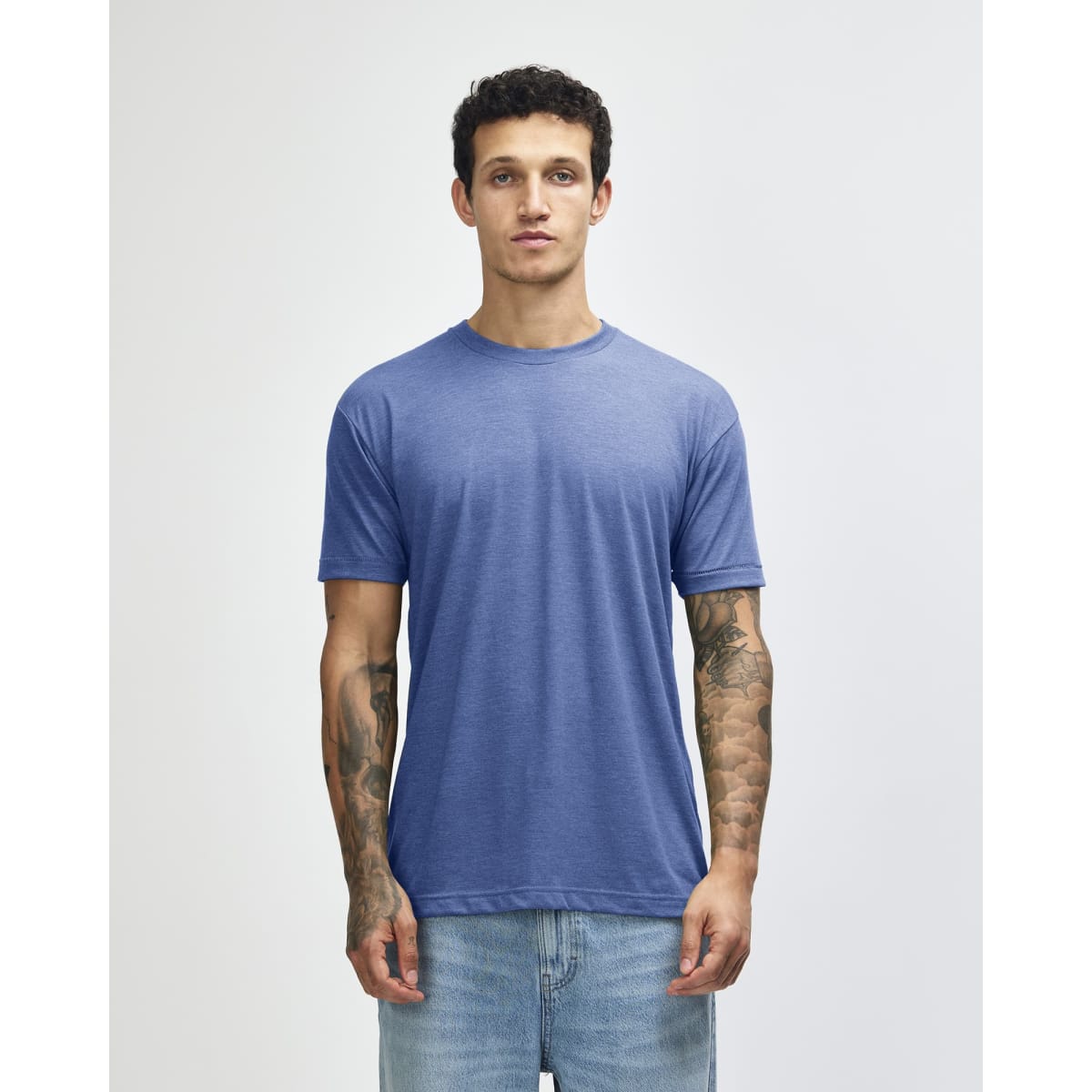 A blue American Apparel tri-blend t-shirt displayed on a model, featuring a relaxed fit and short sleeves.