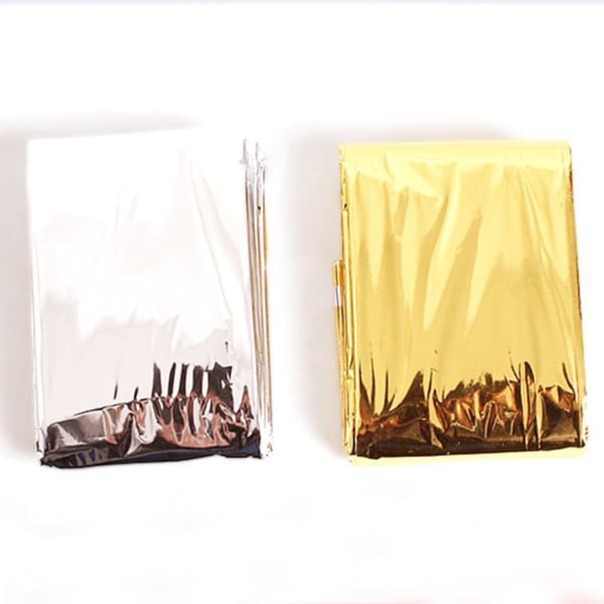 Two large outdoor emergency blankets in silver and gold colours, each wrapped in a shiny, reflective material.