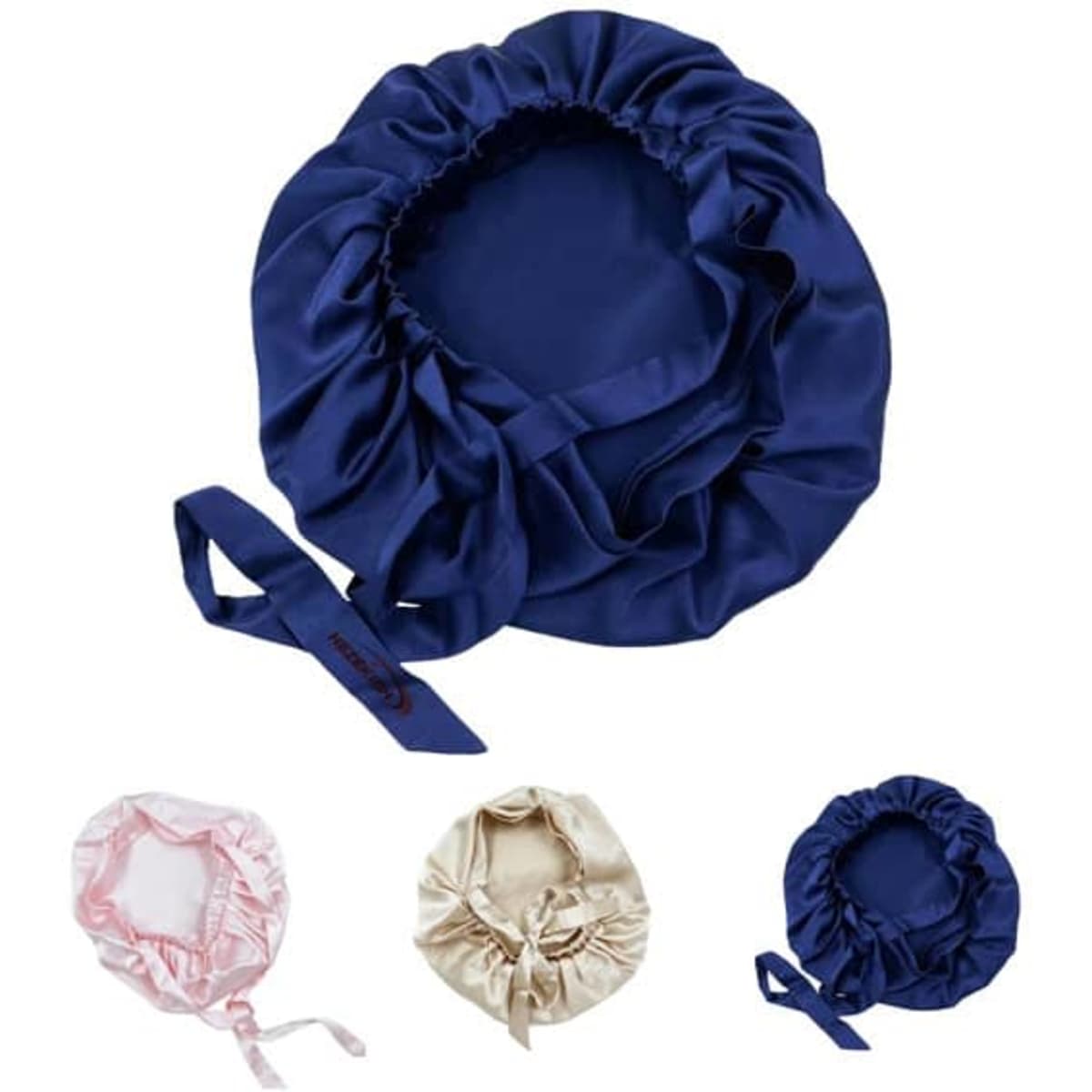 A set of silk nightcaps in navy blue, pink, and cream, featuring soft, gathered fabric and ribbon ties.