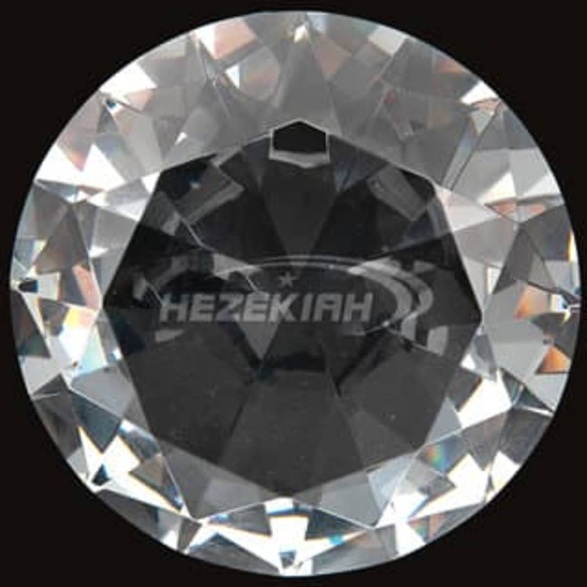 A diamond-shaped paperweight featuring a clear, faceted surface, with a logo in the centre.