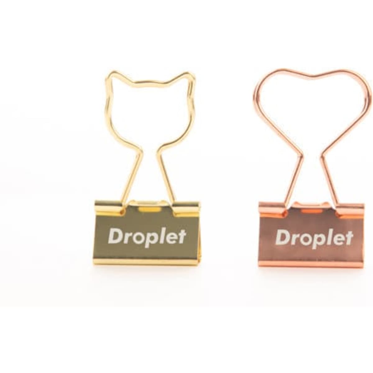 A gold and rose gold metal binder clip, featuring a cat and heart design, with a logo on the front.