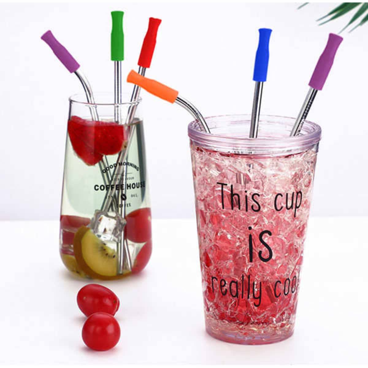 A set of stainless steel straws in various colours, with a pouch, alongside two drink containers filled with beverages and fruit.