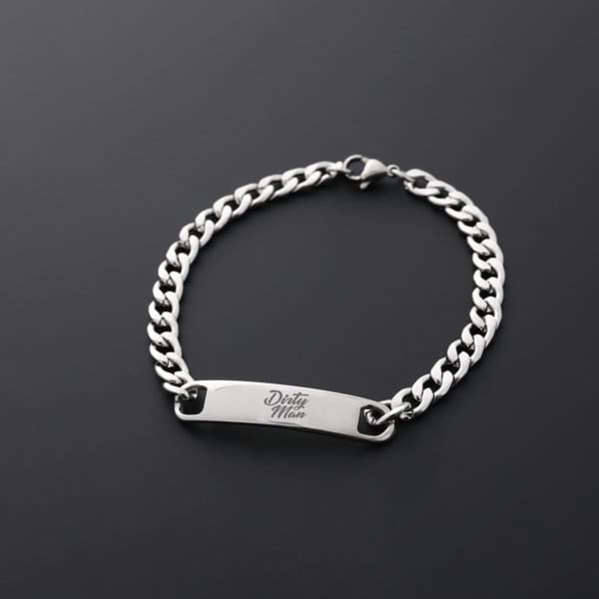 A stainless steel nameplate bracelet with a chunky chain design and engraved plate. The metal has a polished finish.