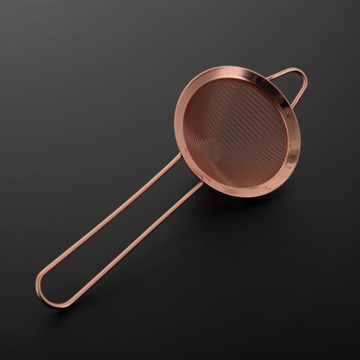 A conical mesh cocktail strainer with a copper finish, featuring a handle and a fine mesh design.