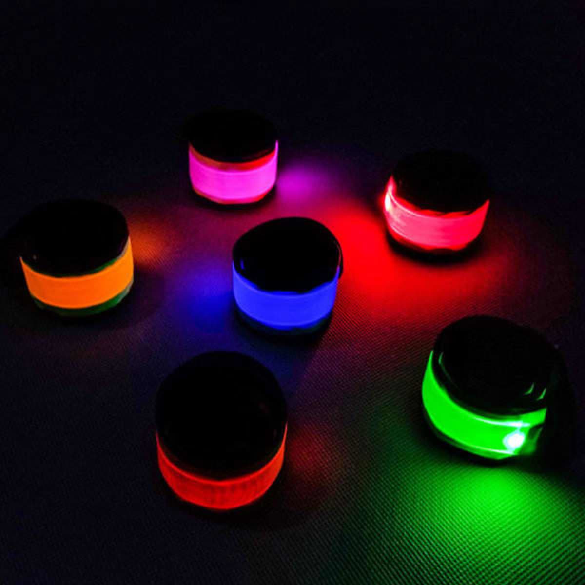A set of six LED luminous slap armbands in orange, pink, blue, green, and purple, featuring a black top and glowing brightly.