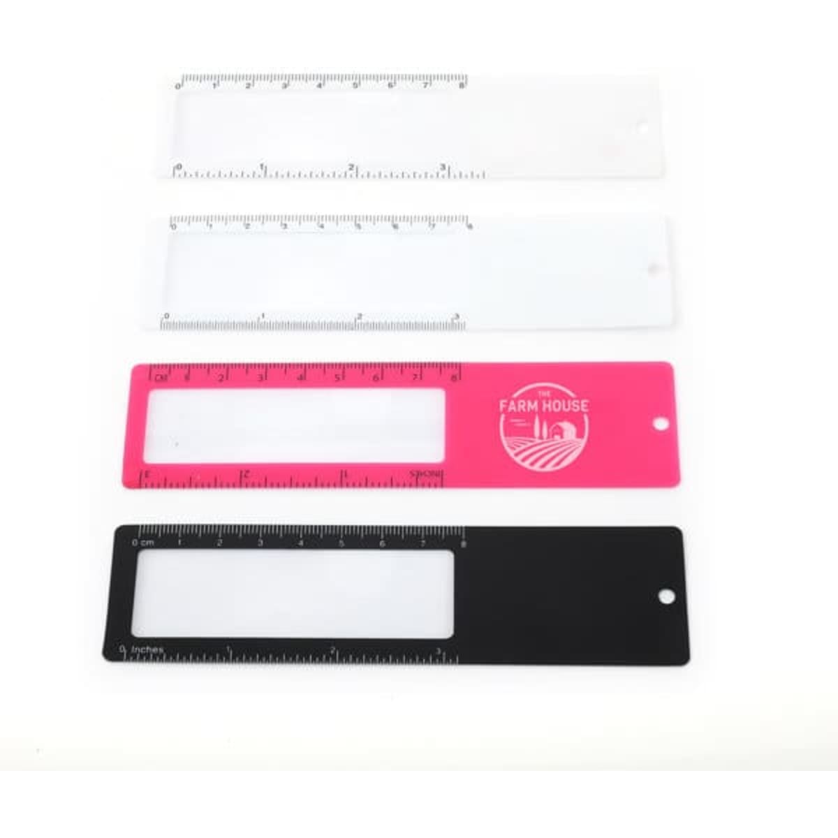 A set of four customised bookmarks with magnifiers in clear, pink, and black, featuring rulers along one edge and a logo.