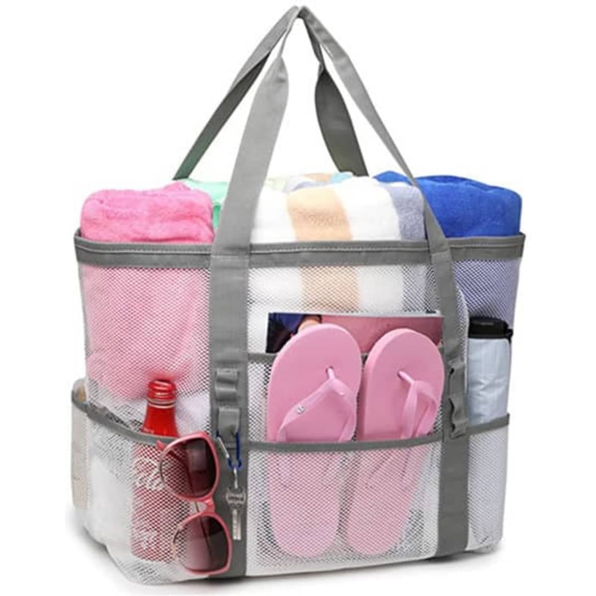 A large grey mesh tote bag filled with towels, flip flops, a drink bottle, and sunglasses.
