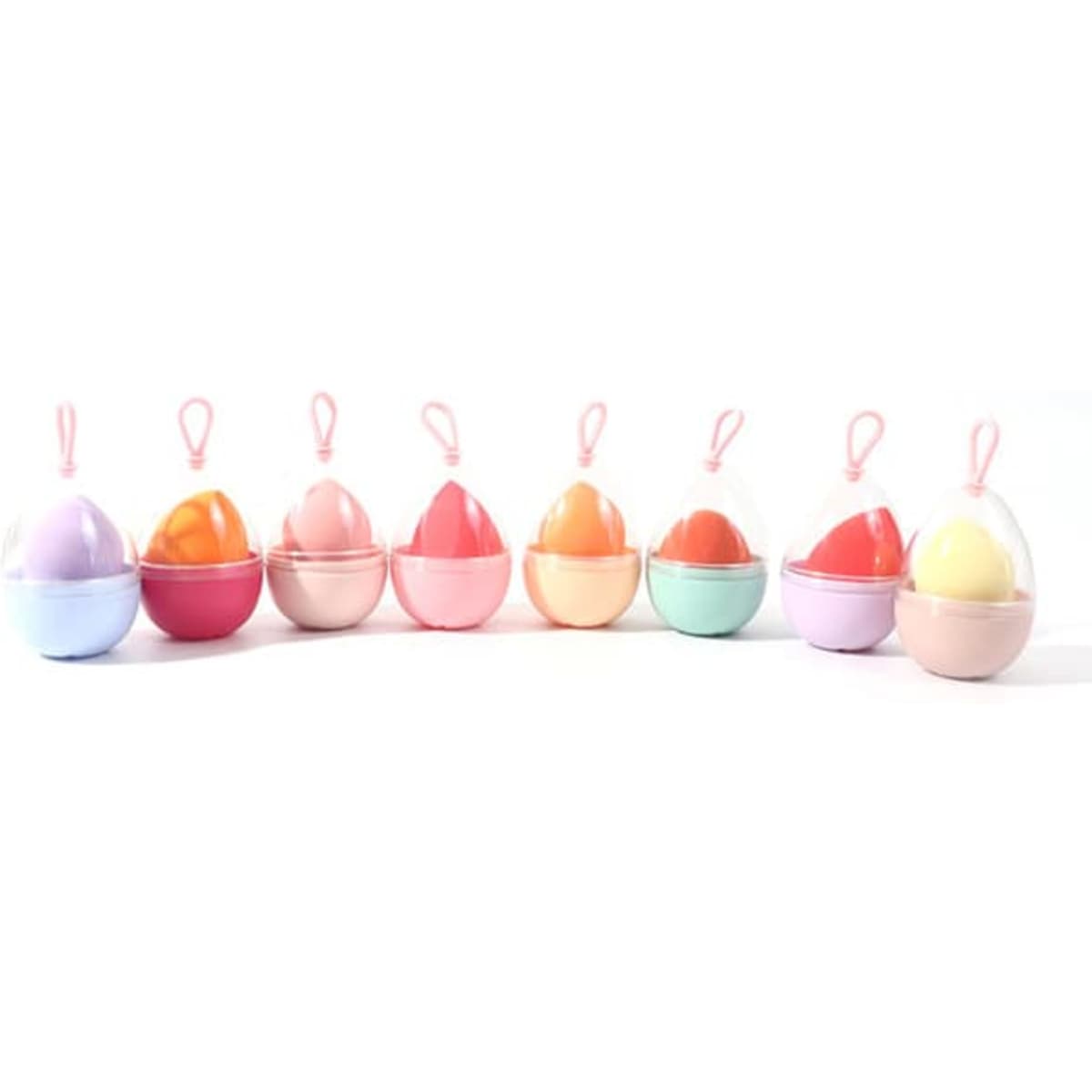A collection of eight pastel-coloured beauty eggs with lanyards, arranged in a row. Each egg features a two-tone design.