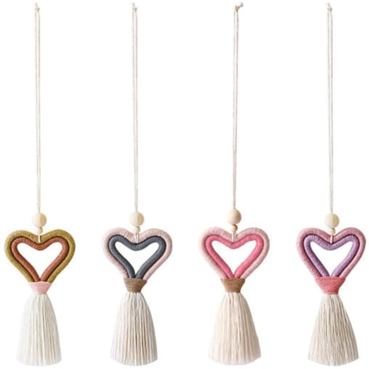 Knitted heart-shaped car pendants in pink, purple, green, and cream, each featuring a tassel. Decorative and colourful novelty items.