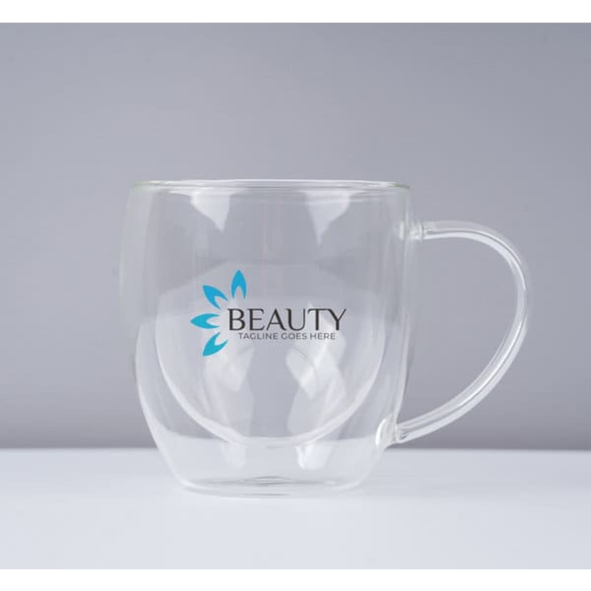 A clear 8 oz. double wall glass coffee cup with a handle and a branding logo.
