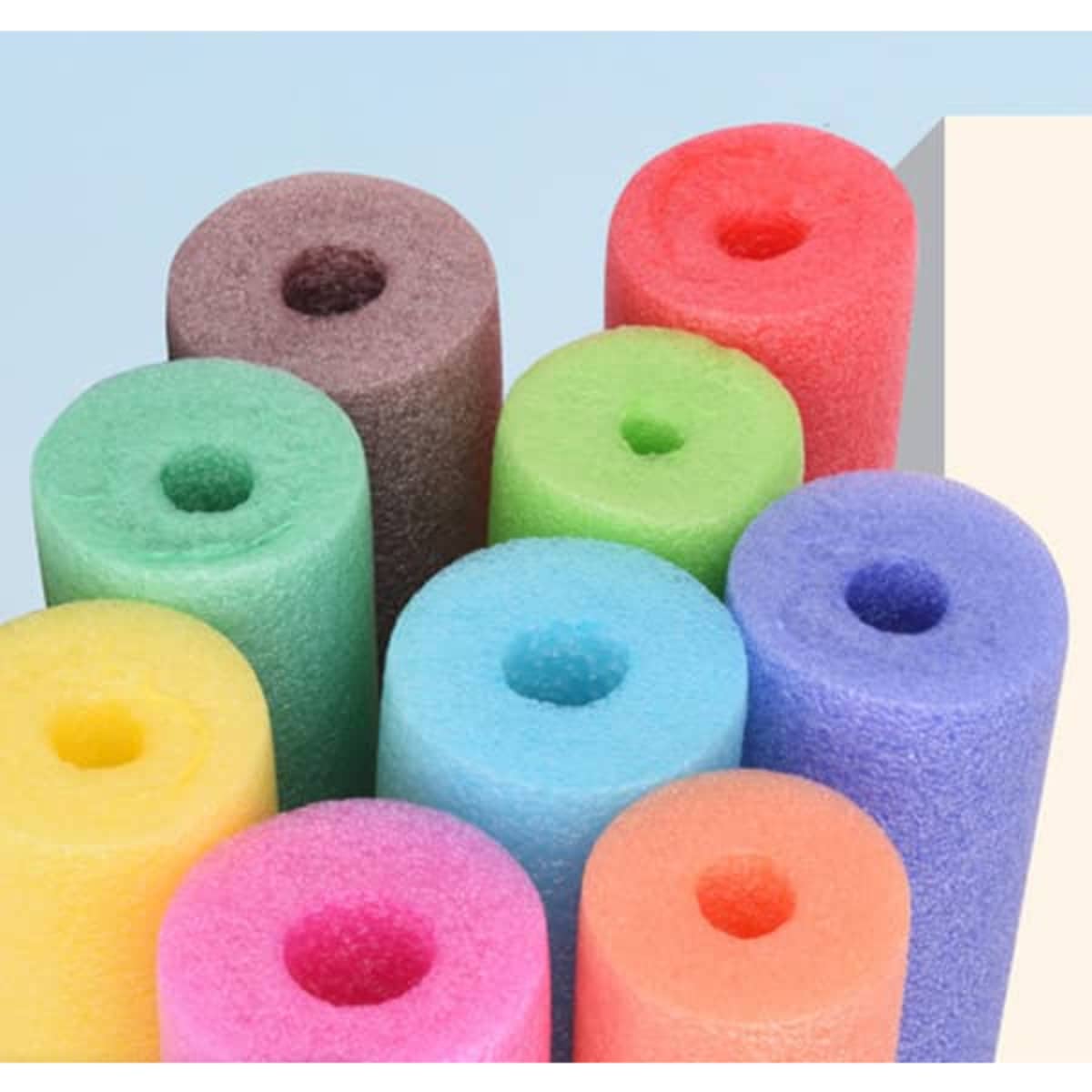A collection of colourful sponge buoyancy sticks in purple, pink, orange, green, blue, and brown, stacked together.
