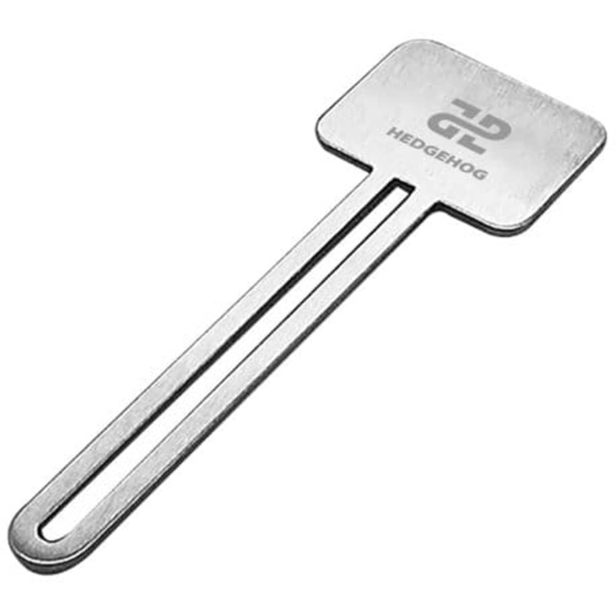A stainless steel toothpaste squeezer with a flat, rectangular head and a long handle. It features a logo.