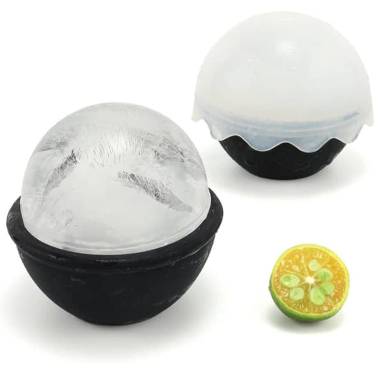 A black silicone ice ball maker with two spherical ice molds, one clear and one with a blue detail, alongside a lime cut in half.