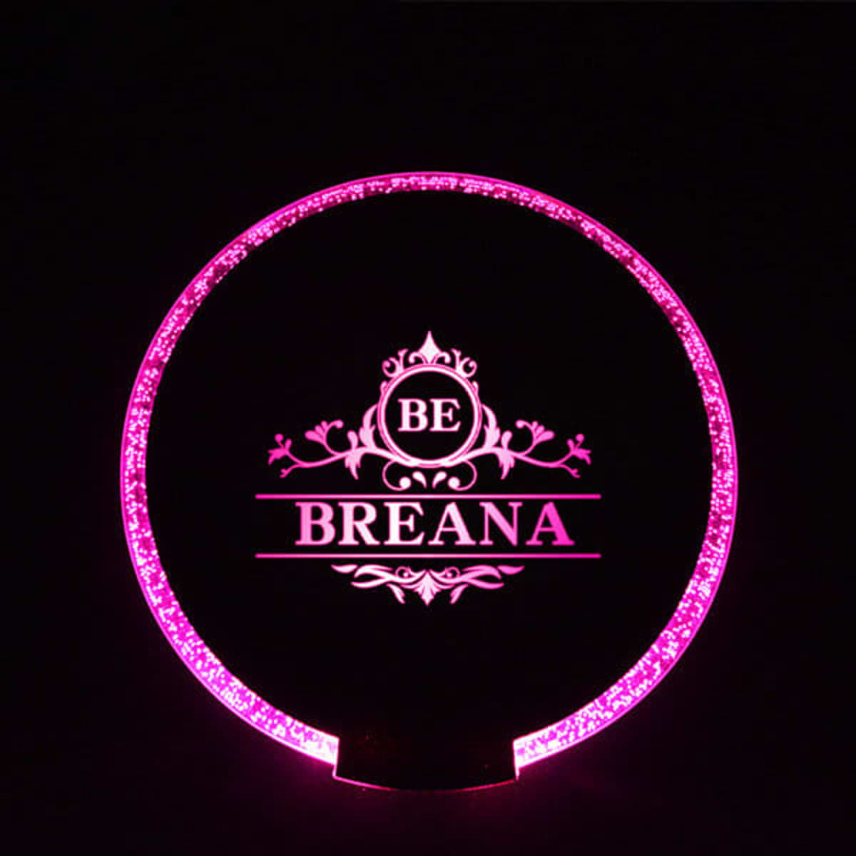 A round LED luminous coaster in pink with a decorative design and branding logo.