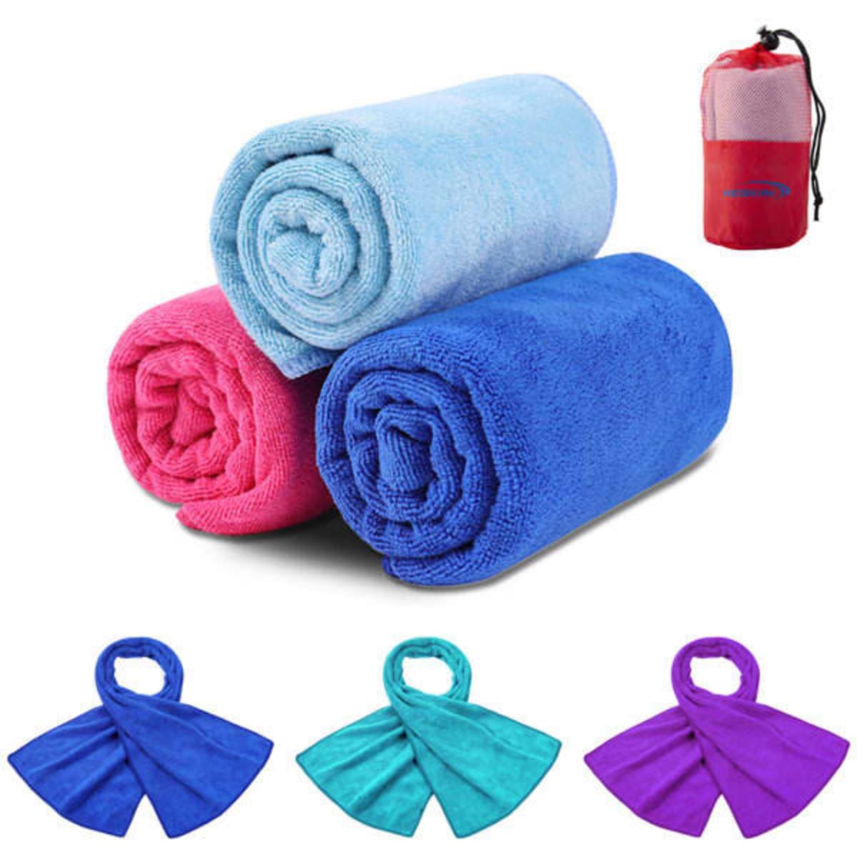 Three rolled towels in blue, pink, and a lighter blue, accompanied by a mesh bag in red and blue.