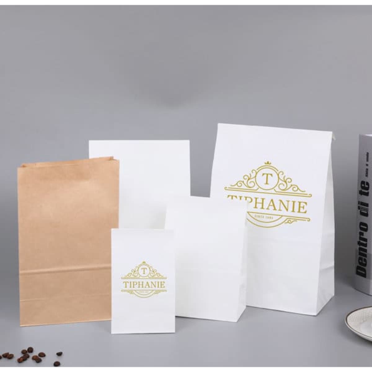 A variety of Kraft paper food bags in white and brown, featuring a logo on the larger bag.
