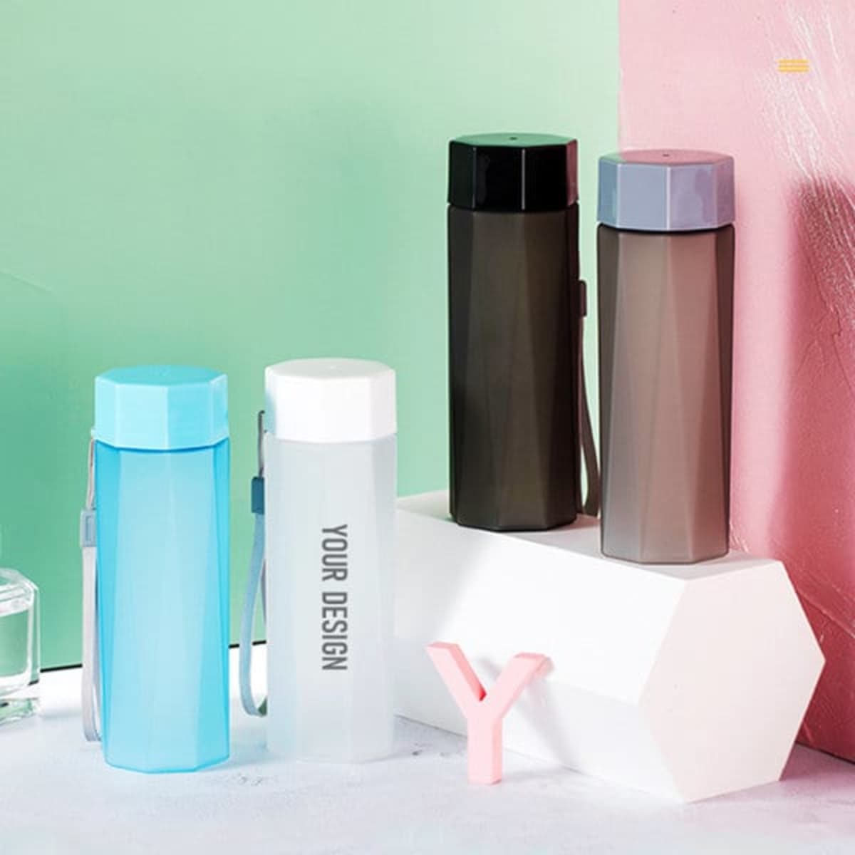 A drink bottle collection featuring frosted finishes in blue, black, grey, and clear, with a logo present on one.