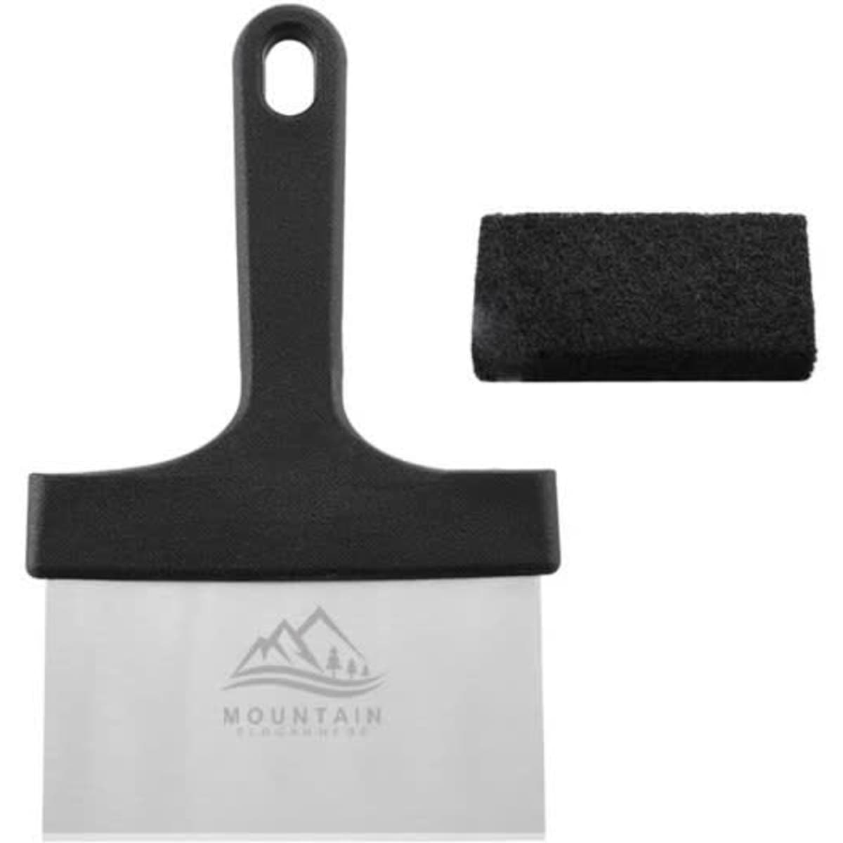A stainless steel griddle scraper with a black handle and a cleaning pad is displayed. It features a logo.