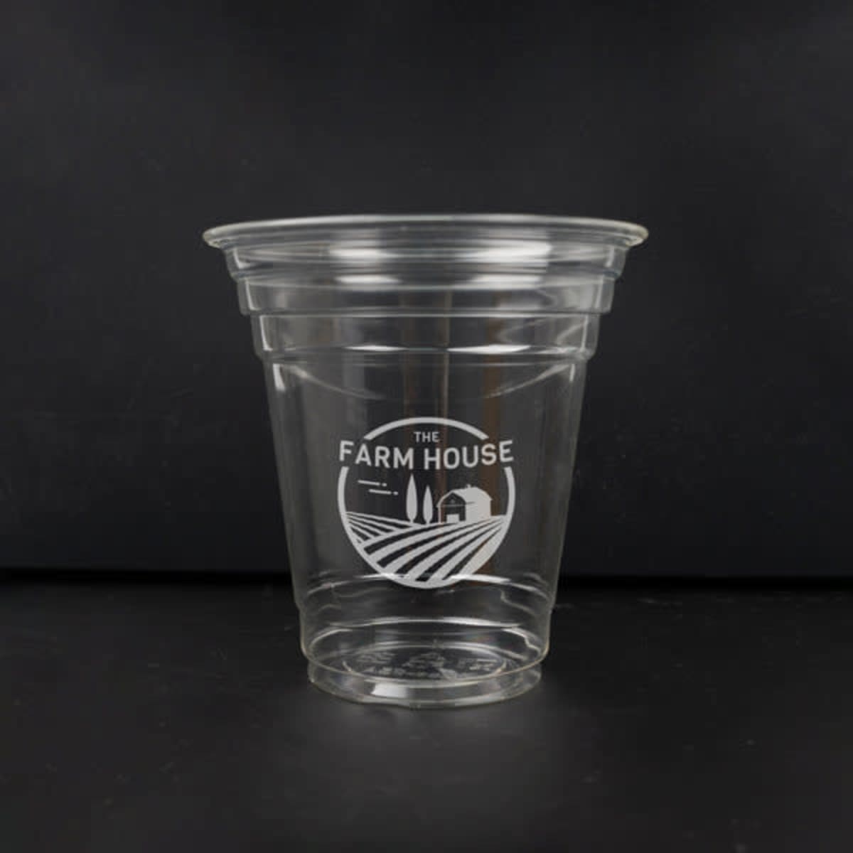 A clear 12 oz. biodegradable disposable PLA cup with a branded logo design.