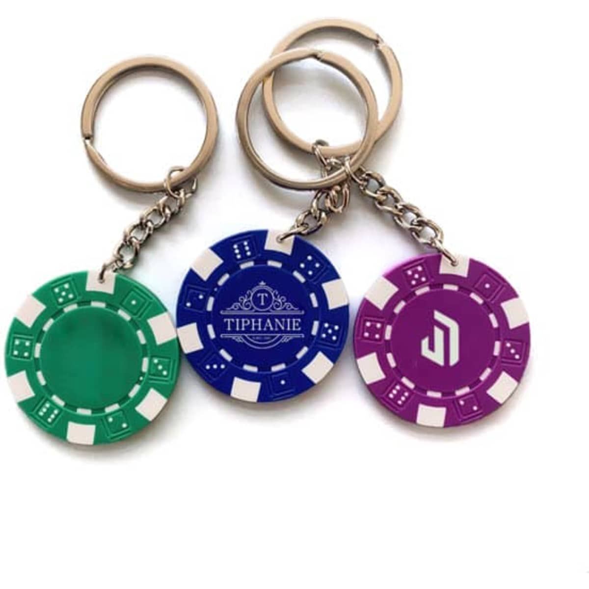 Three poker chip keychains in green, blue, and purple, attached to silver key rings, each featuring a logo.
