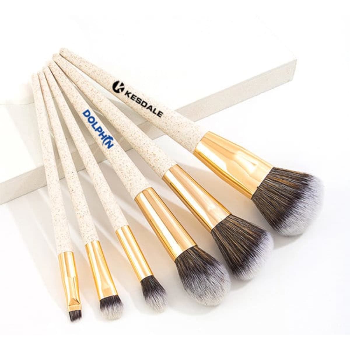 A biodegradable wheat straw makeup brush set featuring five brushes with gold detailing and soft bristles.