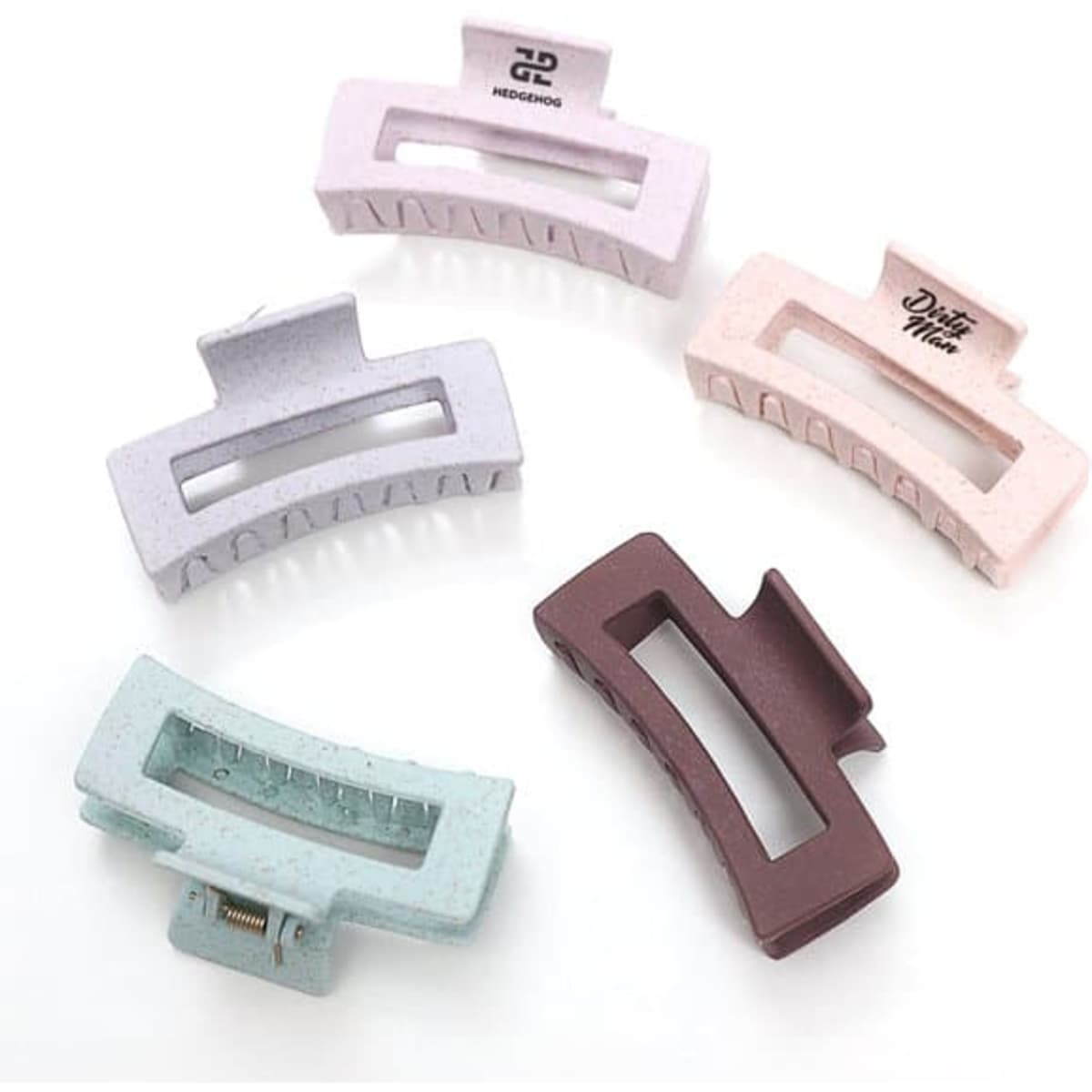 A set of five wheat straw hair claw clips in pastel pink, lavender, mint green, and brown colours, featuring a logo on one clip.