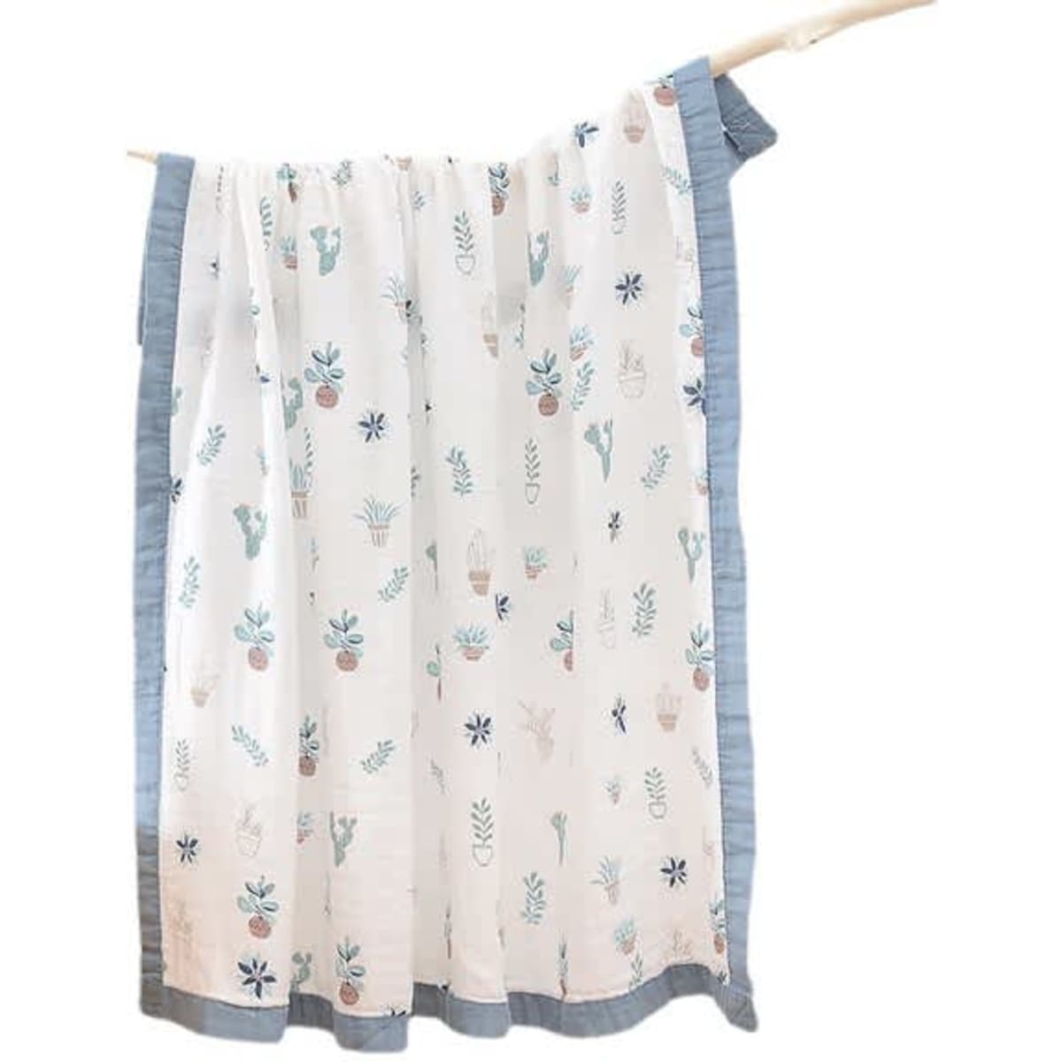 A bamboo cotton baby blanket featuring a light background with colourful plant and flower patterns, bordered in blue.
