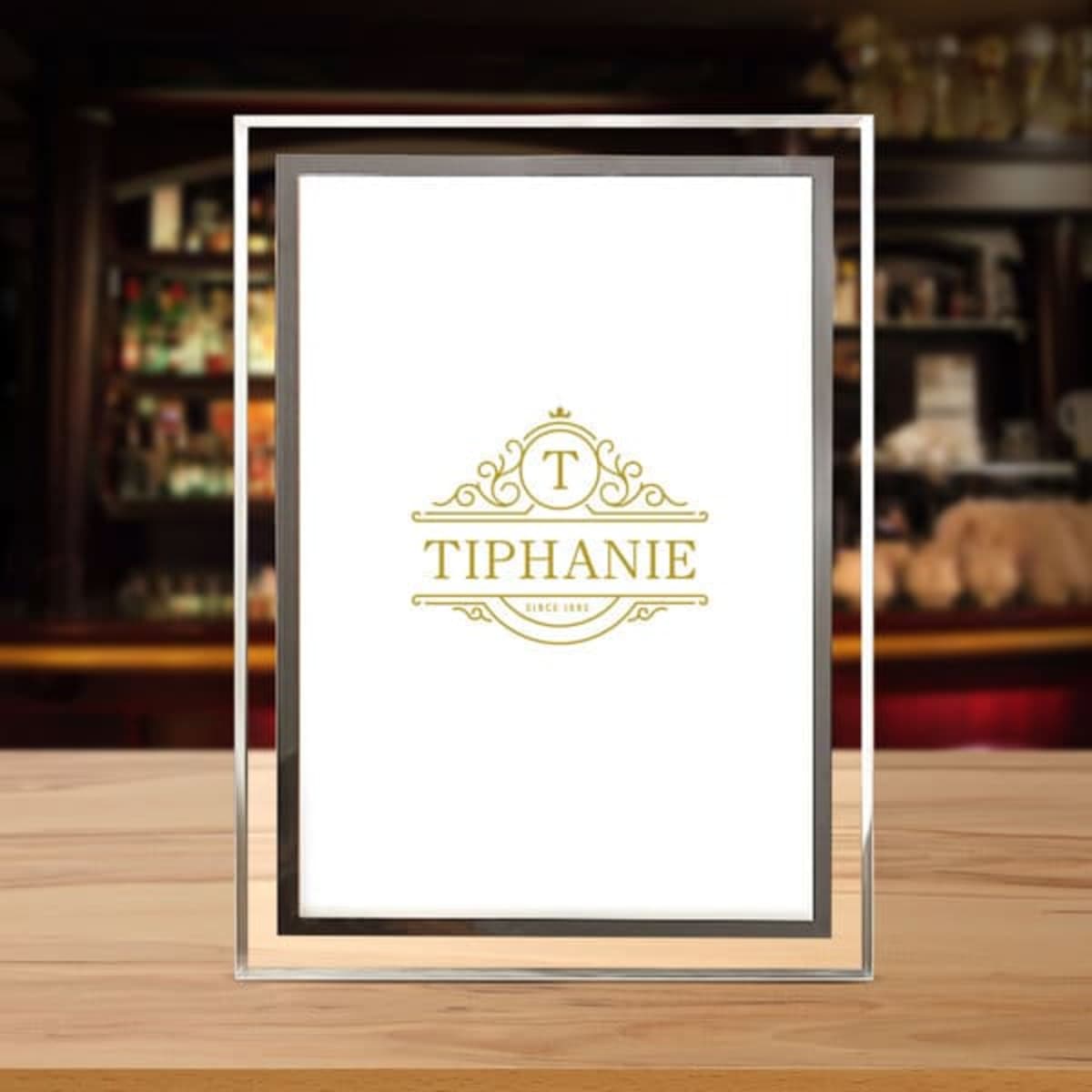 A crystal glass photo frame with a gold logo design on a white background, showcasing a stylish, elegant appearance.