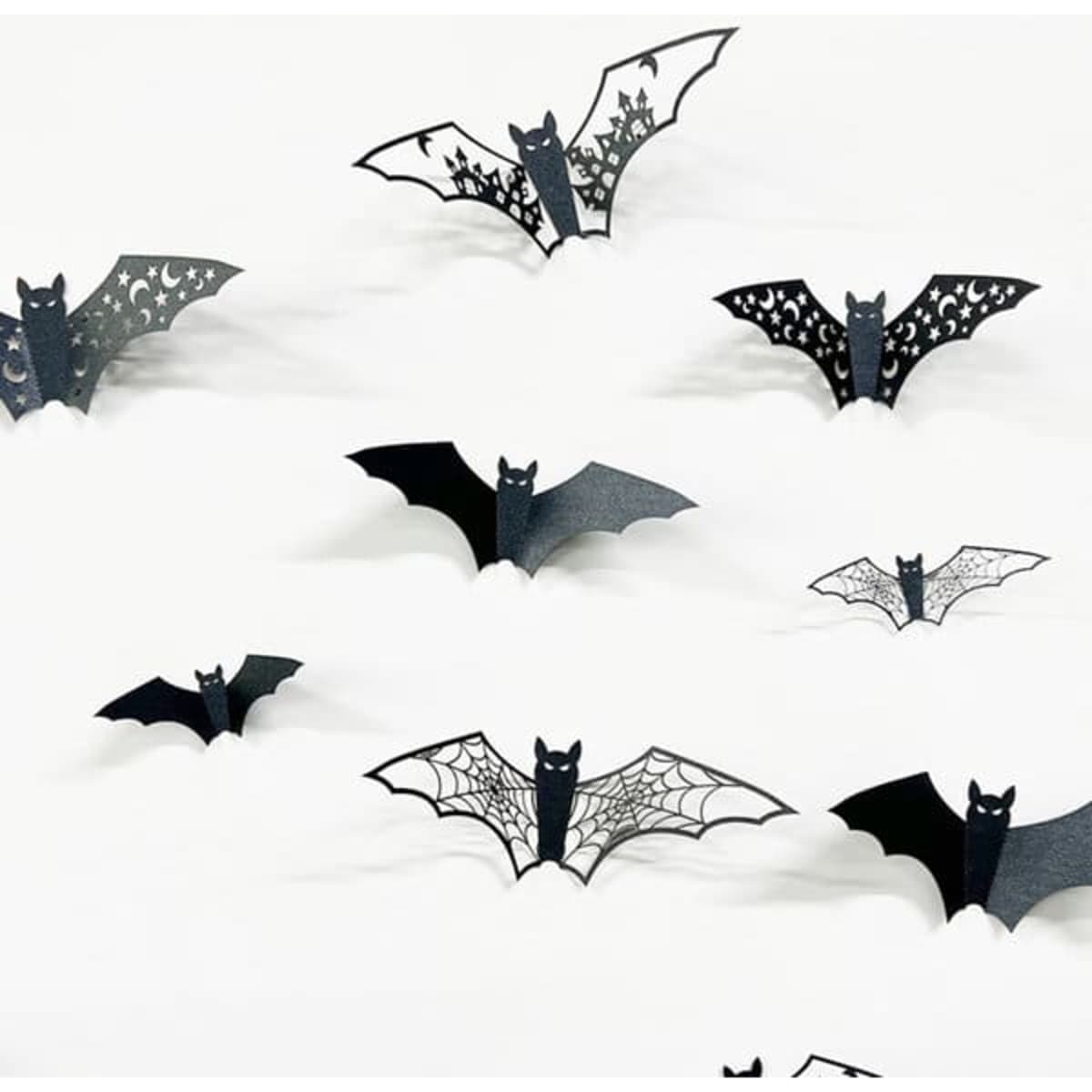 A set of black 3D bat stickers in various designs, featuring patterns like webbing and stars.