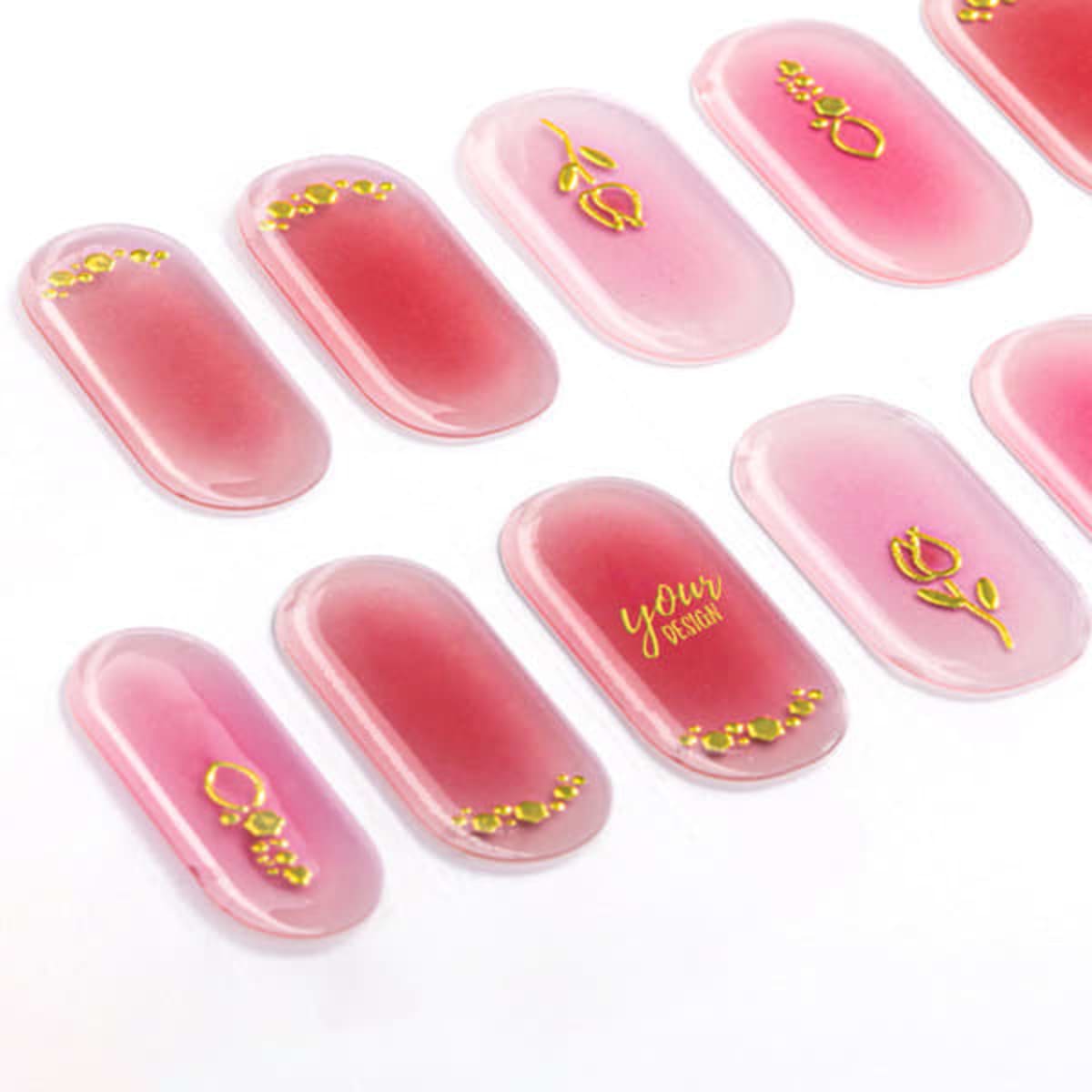 Gel nail stickers in shades of pink with decorative gold designs, displaying a variety of patterns and styles.