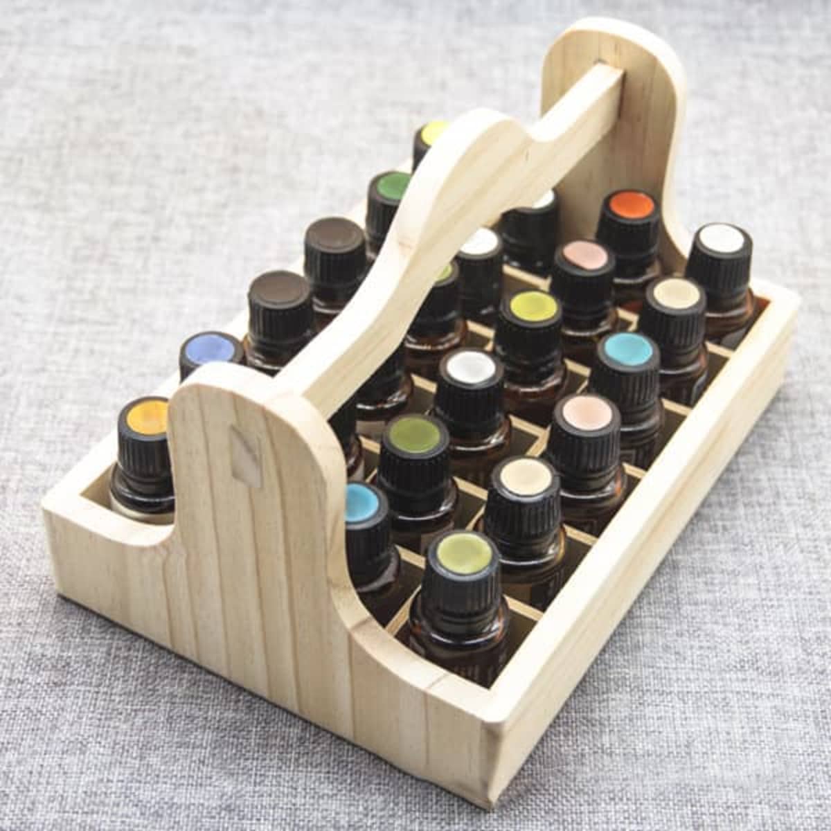 A wooden essential oil organizer in natural colour, holding multiple bottles with various coloured lids.