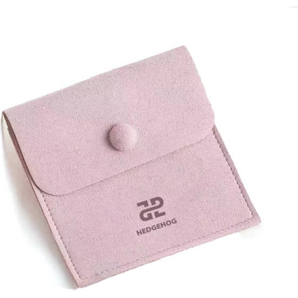 A pink microfiber jewelry pouch with a snap button closure and a logo on the front.