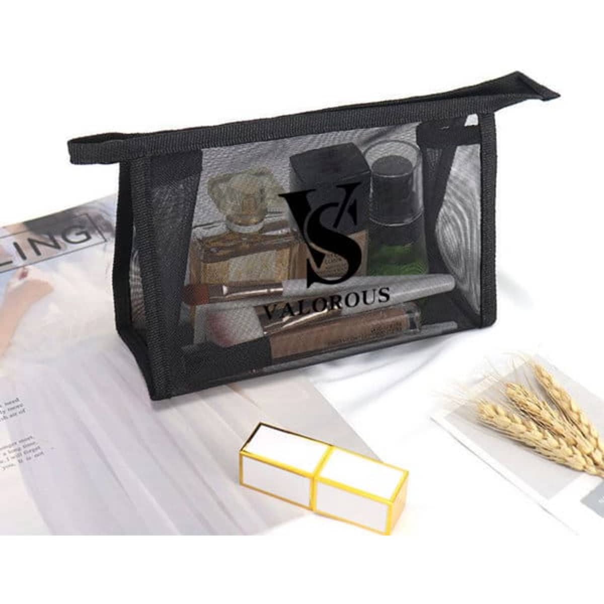 A black mesh makeup bag contains various cosmetic items and has a logo on the front.