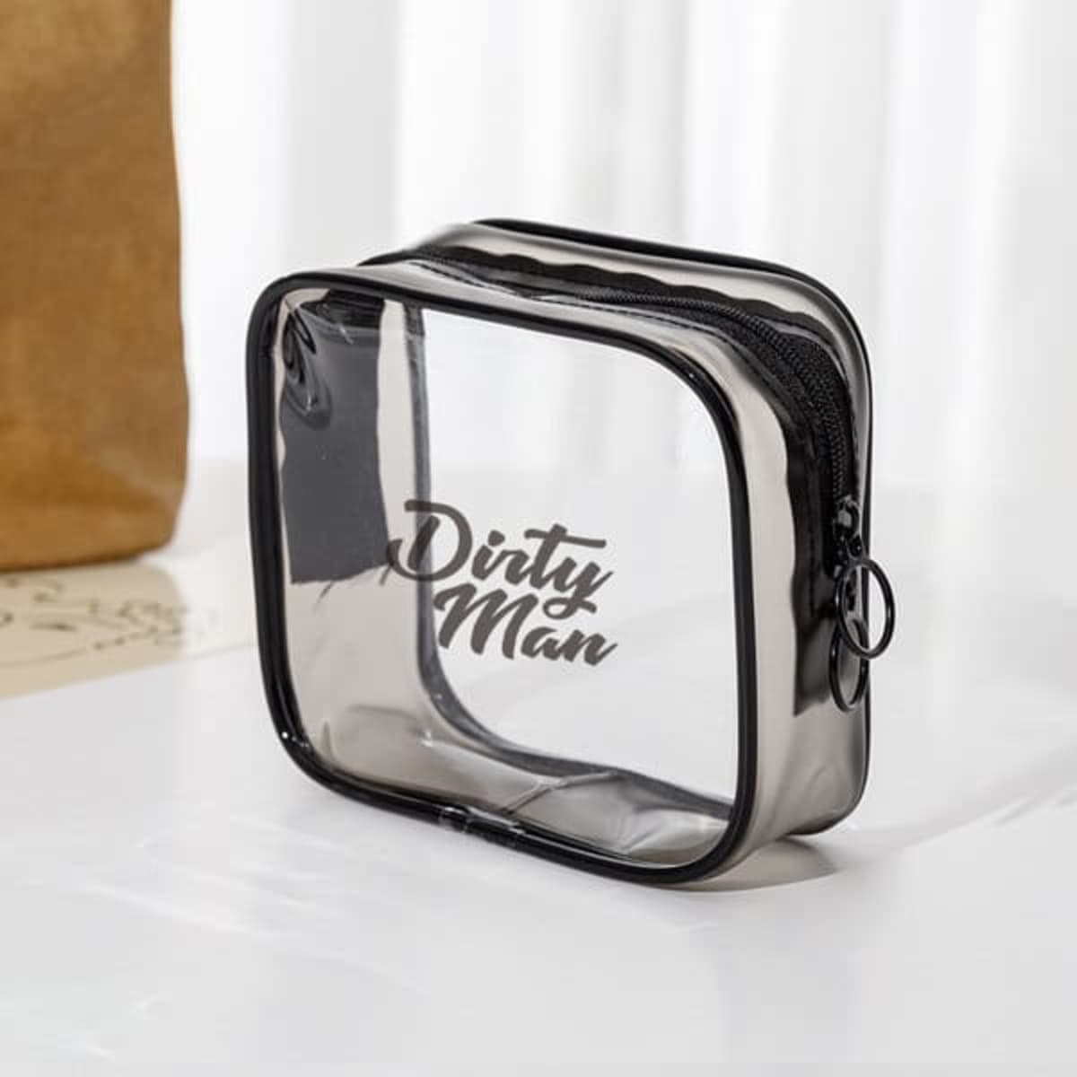 A small clear PVC zippered toiletry bag in black, featuring a branded logo on the front.