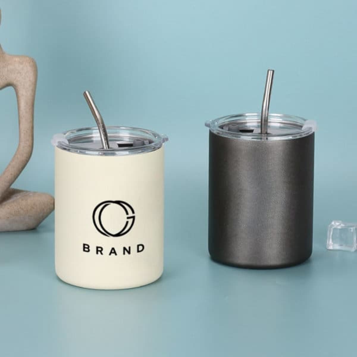 A drink bottle collection featuring a cream and a matte black insulated tumbler with metal straws and branding.