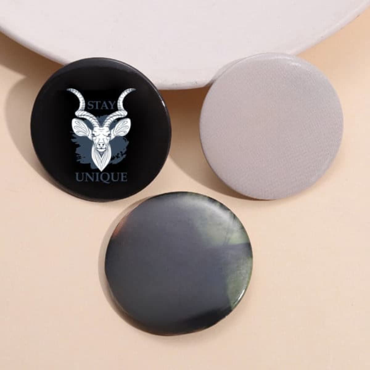 Three custom pinback buttons in black and grey, featuring a design with a goat illustration and a blank one.
